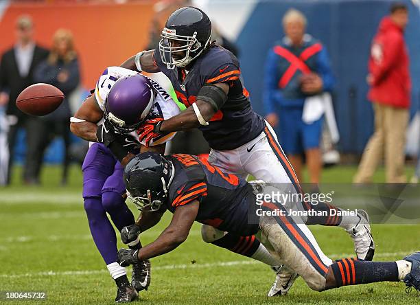 Jarius Wright of the Minnesota Vikings looses control of the ball as he is hit by Charles Tillman and Major Wright of the Chicago Bears at Soldier...