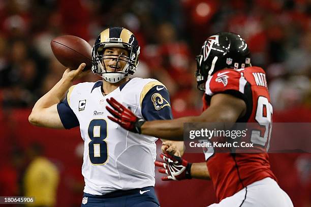 Sam Bradford of the St. Louis Rams is pressured by Cliff Matthews of the Atlanta Falcons at Georgia Dome on September 15, 2013 in Atlanta, Georgia.