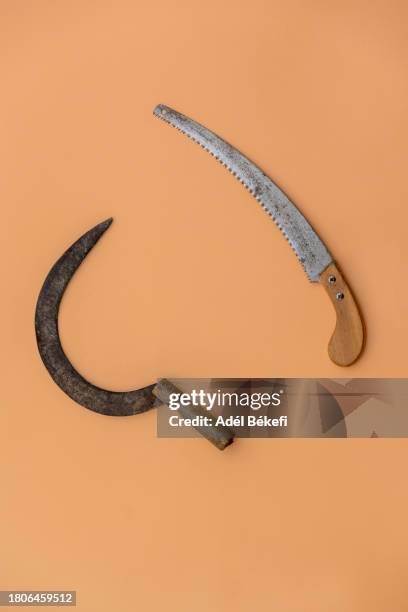 sickle and saw on the orange background - sickle hammer stock pictures, royalty-free photos & images
