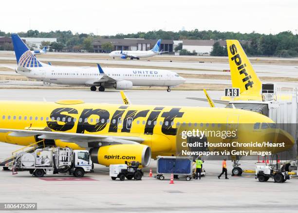 Ground crews work to prepare a Spirit Airlines plane as a United Airlines plane passes by at George Bush Intercontinental Airport, Tuesday, Nov. 21...