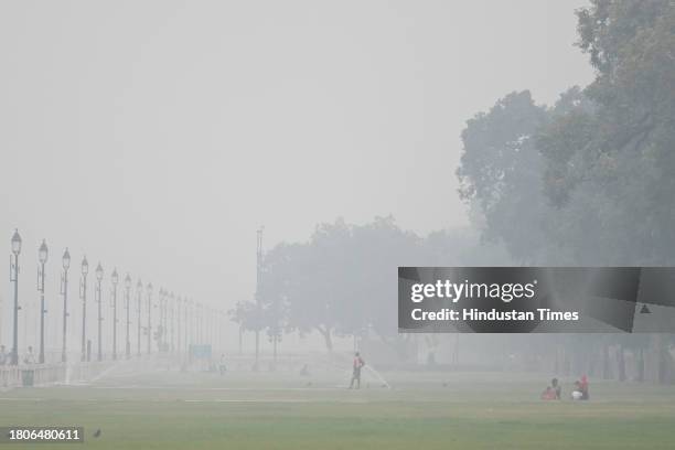 Visitors seen during light drizzle and a cold day at Central Vista Lawns near India Gate on November 27, 2023 in New Delhi, India.