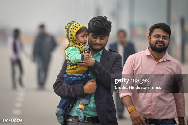 Visitors seen during light drizzle and a cold day at Kartavya Path near India Gate on November 27, 2023 in New Delhi, India.