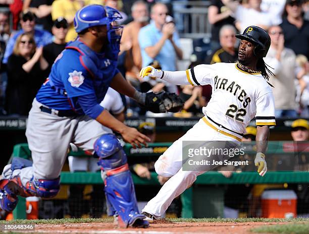 Andrew McCutchen of the Pittsburgh Pirates scores in front of Welington Castillo of the Chicago Cubs during the eighth inning on September 15, 2013...