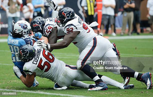 Chris Johnson of the Tennessee Titans is tackled by a group of Houston Texans at Reliant Stadium on September 15, 2013 in Houston, Texas.
