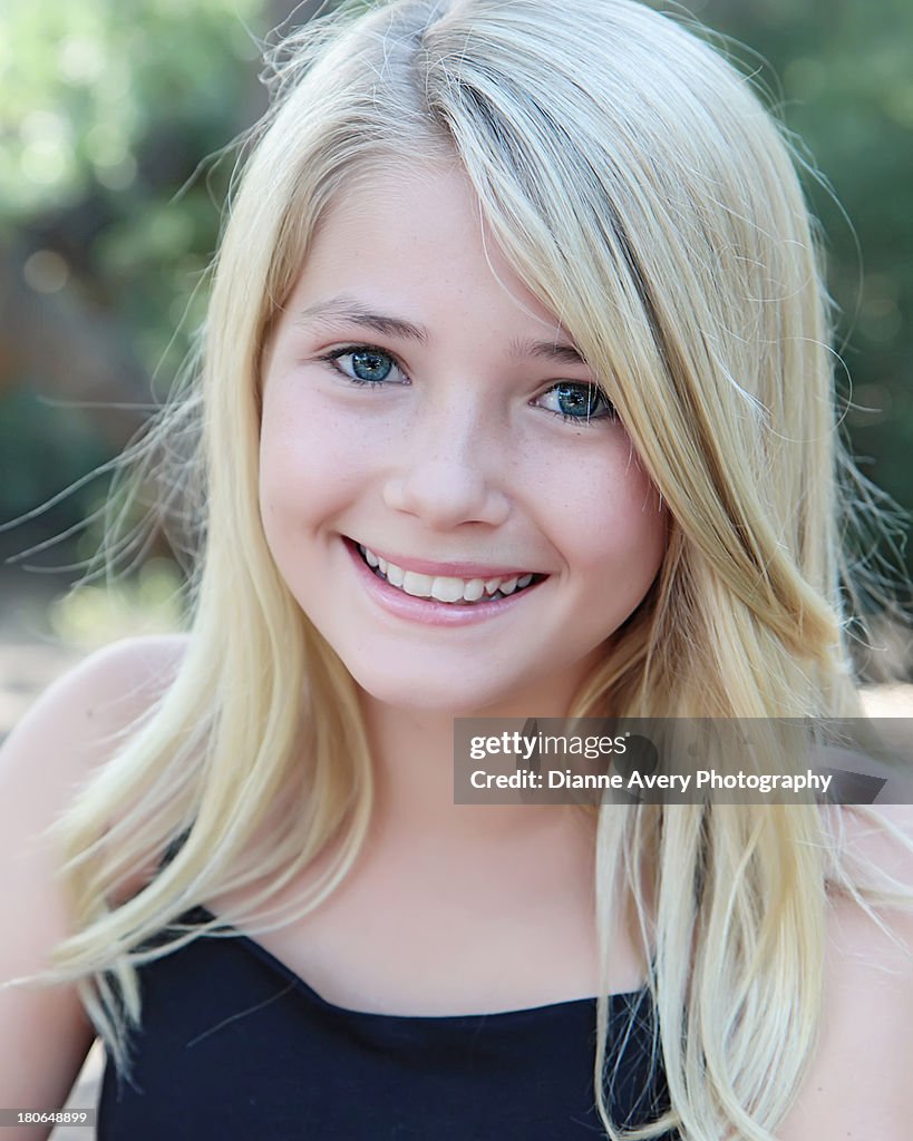 Head shot of young blond girl with big smile