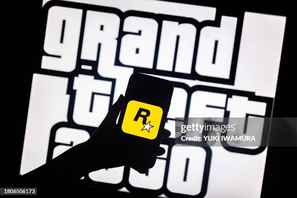 This illusttation shows a logo of Rockstar Games on a smartphone screen and a logo of a video game series Grand Theft Auto on a TV screen in New...