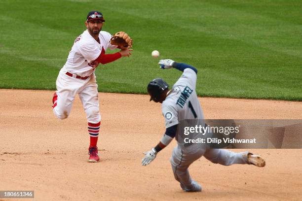 Daniel Descalso of the St. Louis Cardinals turns a double play over Carlos Triunfel of the Seattle Mariners in the seventh inning at Busch Stadium on...