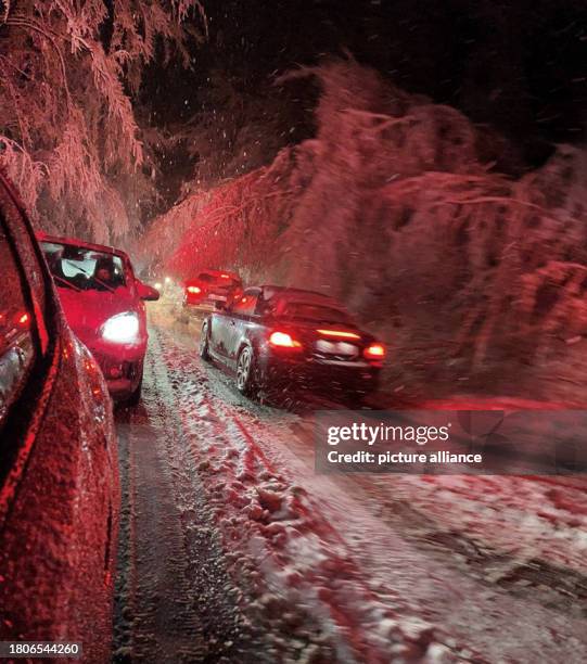 November 2023, Hesse, Wiesbaden: Cars are stuck on the snow-covered B455 federal highway near Wiesbaden. The onset of winter has led to considerable...