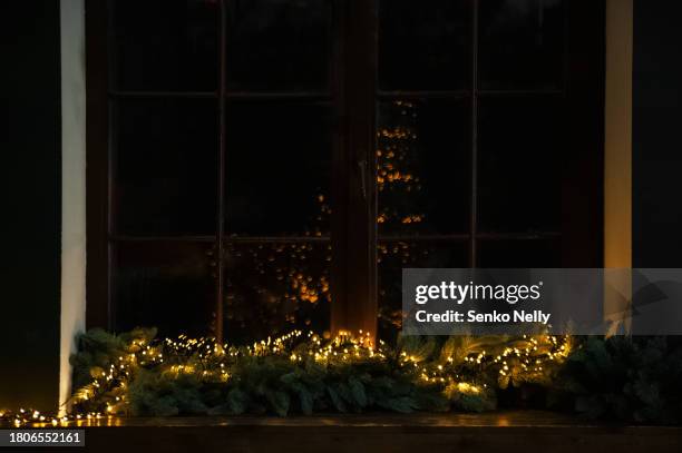 christmas living room decor in green colors. window with christmas garland on windowsill - fensterrahmen stock-fotos und bilder