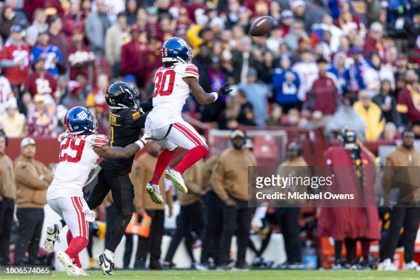 Darnay Holmes of the New York Giants intercepts a pass intended for Jahan Dotson of the Washington Commanders during an NFL football game between the...