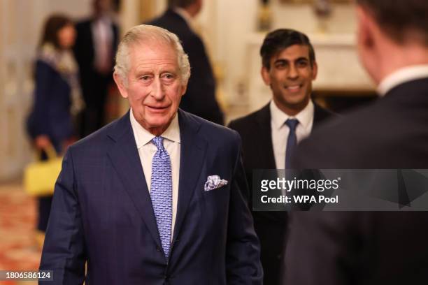 Britain's Prime Minister Rishi Sunak and King Charles III arrive to a Global Investment Summit Reception at Buckingham Palace on November 27, 2023 in...
