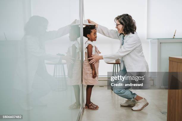 kind beim arzttermin beim messen der körpergröße - messinstrument stock-fotos und bilder