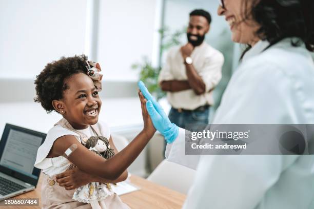 happy child after being vaccinated father taking his daughter to the doctor - children vaccination stock pictures, royalty-free photos & images