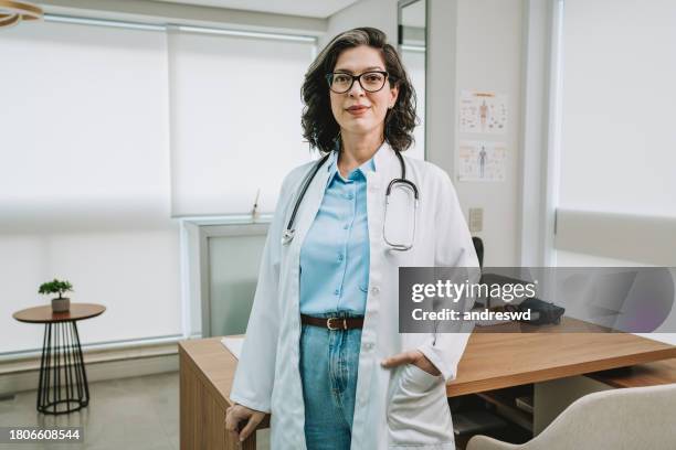 portrait of a female doctor at the workplace - doctor stockfoto's en -beelden