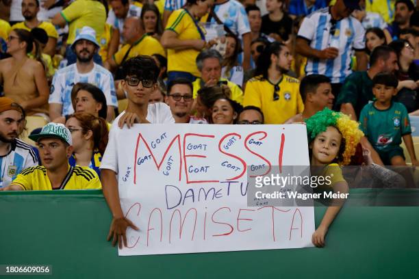 Fans hold a sign asking Lionel Messi for his jersey prior to a FIFA World Cup 2026 Qualifier match between Brazil and Argentina at Maracana Stadium...
