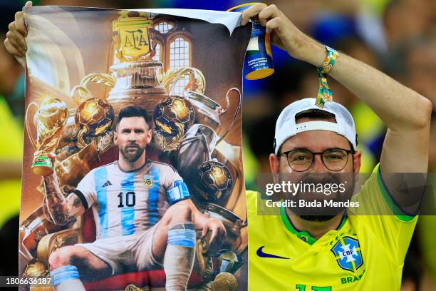 Fan of Brazil holds a poster of Lionel Messi prior to a FIFA World Cup 2026 Qualifier match between Brazil and Argentina at Maracana Stadium on...