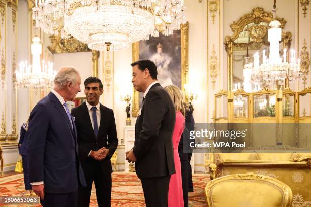 Britain's King Charles III and Britain's Prime Minister Rishi Sunak speak with CEO of Nissan Makoto Uchida at Buckingham Palace to mark the...