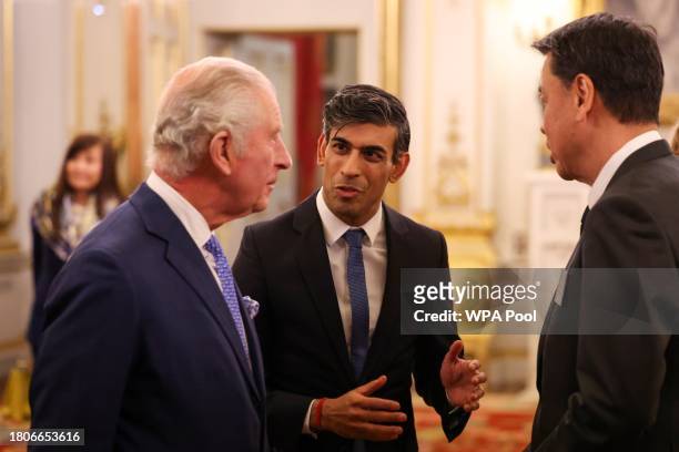 Britain's King Charles III and Britain's Prime Minister Rishi Sunak speak with CEO of Nissan Makoto Uchida at Buckingham Palace to mark the...