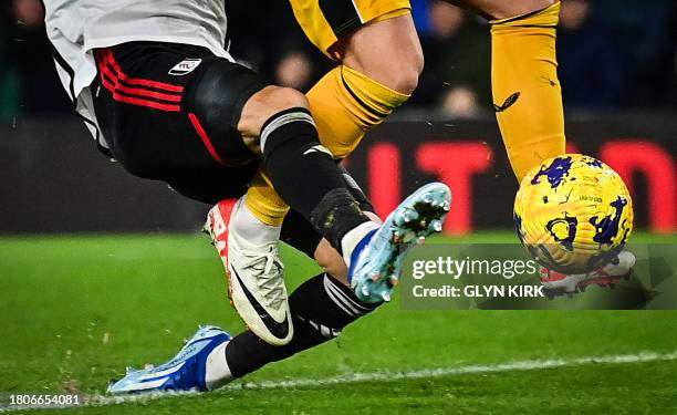 Fulham's Belgian defender Timothy Castagne fights for the ball with Wolverhampton Wanderers' Northern Irish defender Matt Doherty during the English...