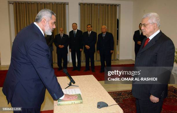 In this image made available by the Palestinian Press Office, 17 March 2007 Prime Minister Ismail Haniya places his hand on the Koran during the...