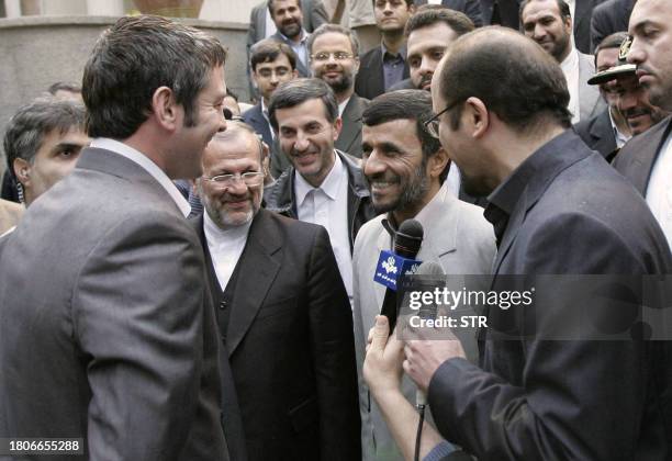 Iranian President Mahmoud Ahmadinejad meets with a British sailor following his press conference in Tehran, where he announced the release of the 15...