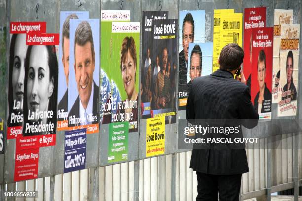 Man looks at official campaign posters displayed in the French southern town of Montpellier, 10 April 2007 as official campaigning for France's...