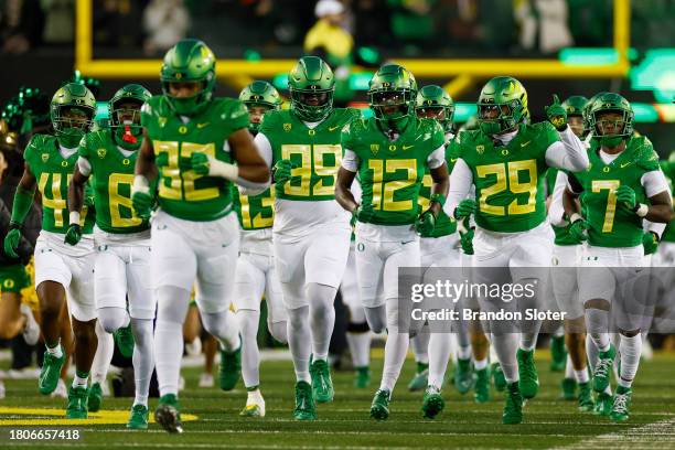 Members of the Oregon Ducks run onto the field prior to a game against the Oregon State Beavers at Autzen Stadium on November 24, 2023 in Eugene,...