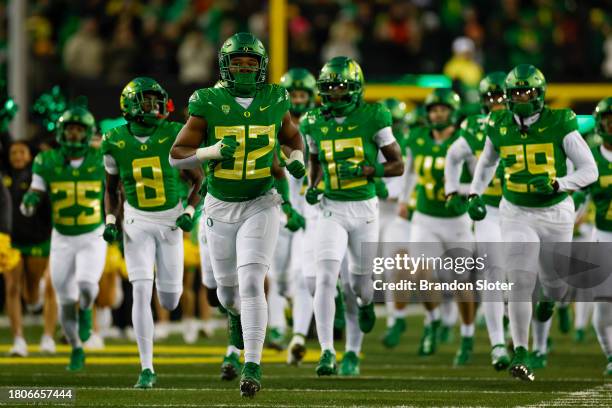 Members of the Oregon Ducks run onto the field prior to a game against the Oregon State Beavers at Autzen Stadium on November 24, 2023 in Eugene,...