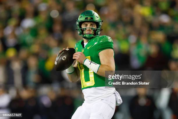 Bo Nix of the Oregon Ducks drops back to pass in the first half during a game against the Oregon State Beavers at Autzen Stadium on November 24, 2023...