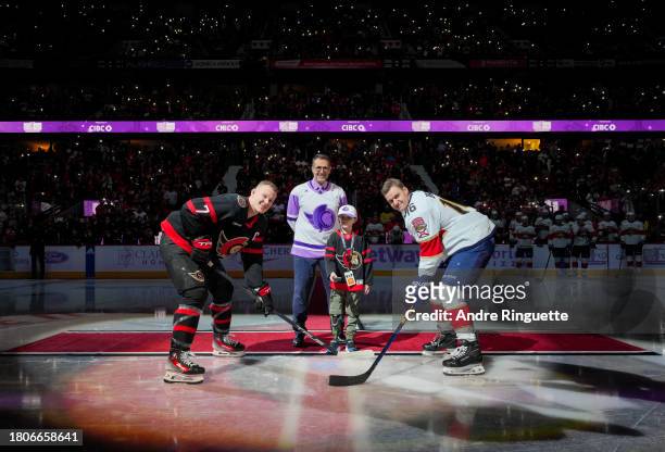 Brady Tkachuk of the Ottawa Senators and Aleksander Barkov of the Florida Panthers take a ceremonial face-off dropped by cancer patient Parker...