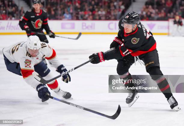 Tim Stützle of the Ottawa Senators shoots the puck against Aleksander Barkov of the Florida Panthers during the first period at Canadian Tire Centre...