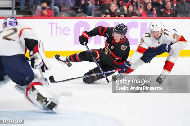 Brady Tkachuk of the Ottawa Senators shoots the puck against Sergei Bobrovsky of the Florida Panthers as he is tripped by Niko Mikkola during the...