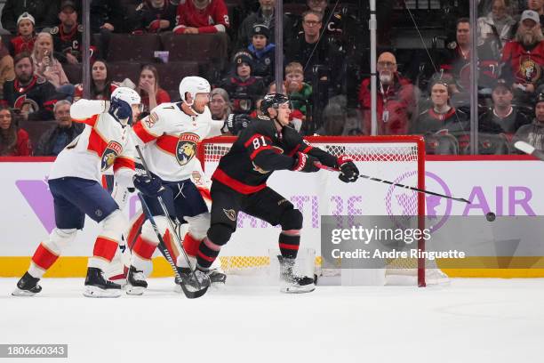 Dominik Kubalik of the Ottawa Senators blocks a shot during the second period as he battles for position against Evan Rodrigues and Dmitry Kulikov of...