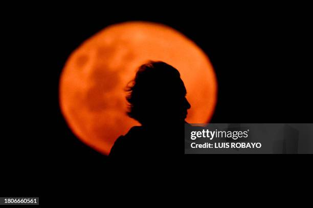 Man's profile is silhouetted against the "beaver moon," as the full moon of November is known as, in Buenos Aires on November 27, 2023.