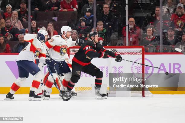 Dominik Kubalik of the Ottawa Senators blocks a shot during the second period as he battles for position against Evan Rodrigues and Dmitry Kulikov of...