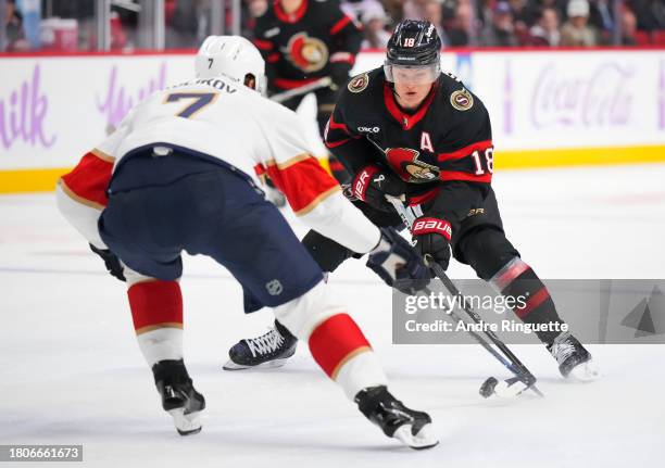 Tim Stützle of the Ottawa Senators stickhandles the puck against Dmitry Kulikov of the Florida Panthers during the third period at Canadian Tire...