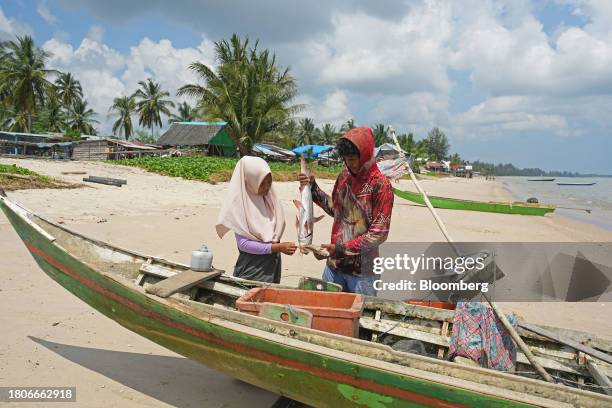 Fisherman holds up fish at Tanah Kuning village near The Kalimantan Industrial Park Indonesia in Bulungan Regency, North Kalimantan, Indonesia, on...