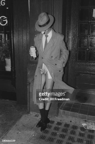 Man in a mask reveals his fake penis on the street in Greenwich Village, New York City, 1983.