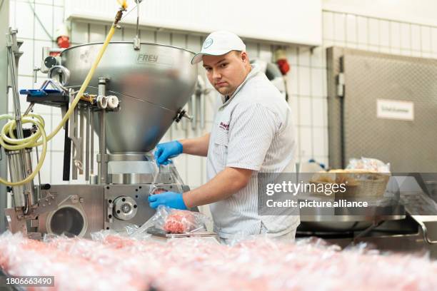 November 2023, Lower Saxony, Wolsdorf: Alexander Richter, butcher, produces bales of meat in his family's butcher's shop "Spezi-Metzger". On the...