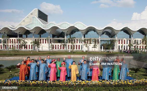 Leaders pose for the traditionnal family photo wearing traditionnal Vietnamese Ao Dai clothes 19 November 200 in Hanoi at the end of the gathering....