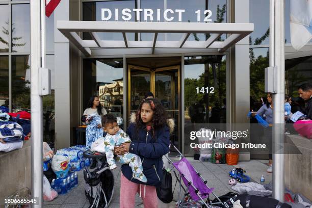 Brianyerlis Carreno from Venezuela, holds her 8-month old brother Mateo Vargas outside the Chicago Police 12th District station, on Tuesday, May 9 on...