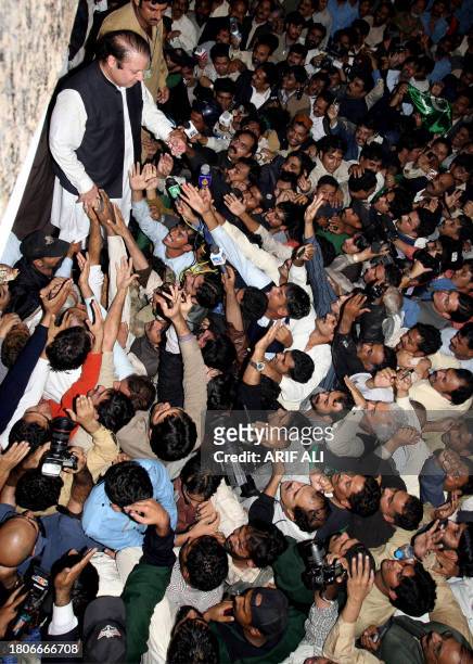 Former Pakistani prime minister Nawaz Sharif is greeted by supporters outside the Allama Iqbal International airport in Lahore, 25 November 2007,...