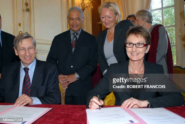 Rouen's mayor Pierre Albertini signs an agreement with New-Zealand ambassador to France Sarah Dennis next to a representative of the Maori community...