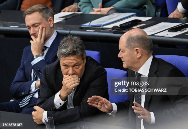 German Chancellor Olaf Scholz, Minister of Economics and Climate Protection Robert Habeck and Finance Minister Christian Lindner talk during a debate...