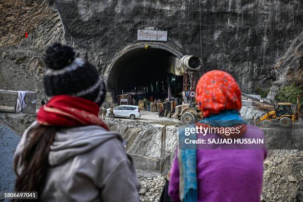 Villagers and locals gather to look at the efforts by the operatives to rescue the 41 men trapped inside the collapsed under construction Silkyara...