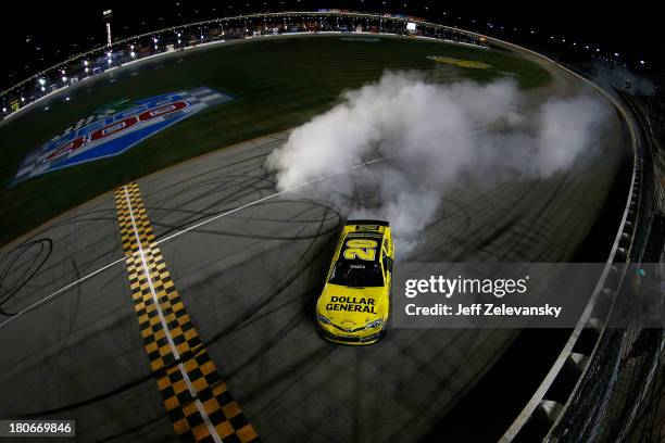 Matt Kenseth, driver of the Dollar General Toyota, celebrates with a burnout after winning the NASCAR Sprint Cup Series Geico 400 at Chicagoland...