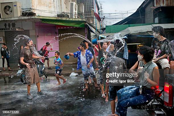 Foreign tourist finds himself in the middle of water wars on the streets of ancient Ayutthaya city, Thailand. The Songkran festival is celebrated in...