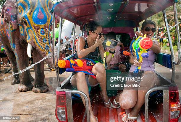 Thai villagers and foreign tourists take part in a water battle with elephants during the Songkran Festival in Ayutthaya province. Songkran,...