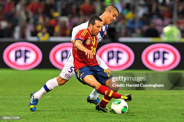 Santi Cazorla of Spain and Francisco Silva of Chile compete for the ball during the Spain v Chile international friendly at Stade de Geneve on...