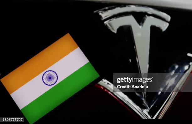 In this photo illustration, Indian flag is displayed on a mobile phone screen in front of the logo of Tesla in Ankara, Turkiye on November 28, 2023.